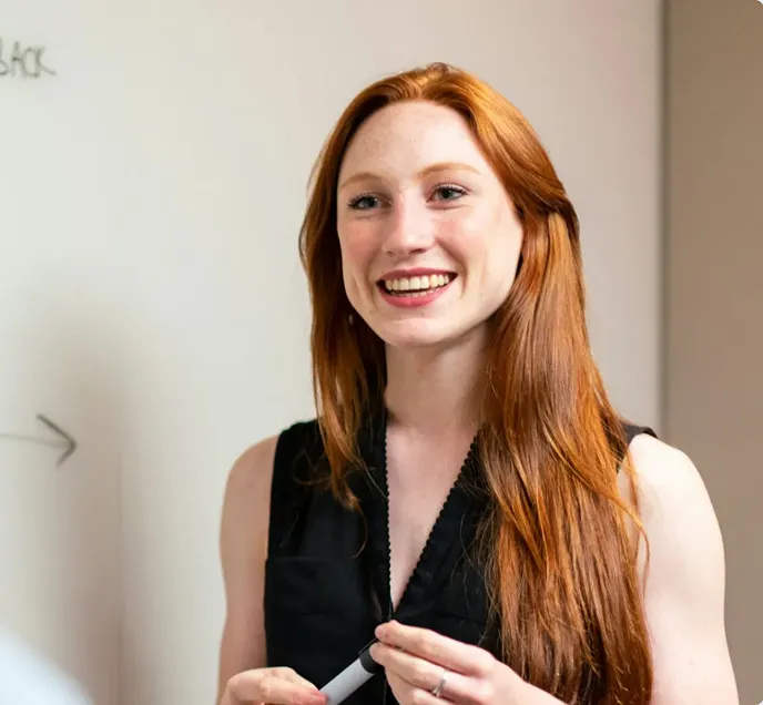 ペンを持っているオレンジヘアの外国人女性